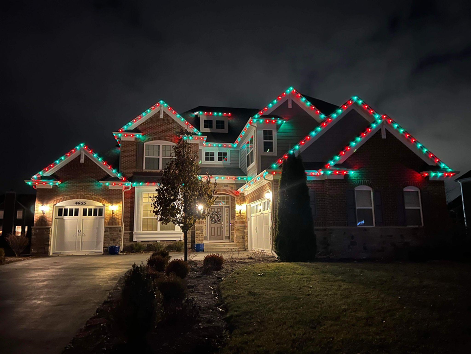 Large home lit in red and green